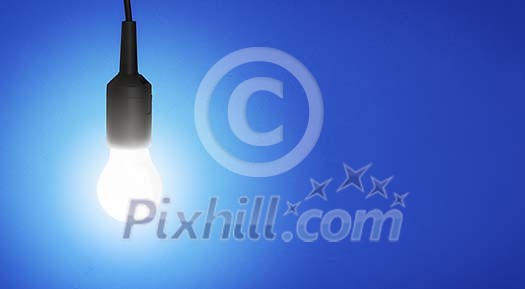 Illuminated lightbulb on a blue background Illuminated lightbulb on a blue background