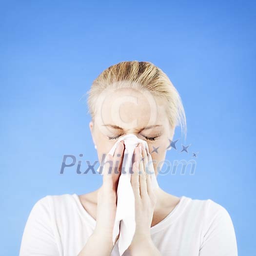 Woman sneezing on a blue background Woman sneezing on a blue background