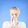 Woman sneezing on a blue background