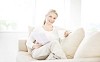 Woman on the couch reading and drinking tea