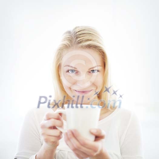 Woman smiling and holding a cup Woman smiling and holding a cup