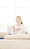 Woman sitting on the couch, having coffee
