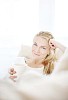 Woman smiling to the camera holding a cup of coffee