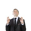 Isolated businessman wishing something fingers crossed