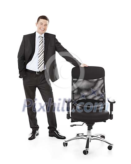 Isolated businessman standing next to a chair Isolated businessman standing next to a chair