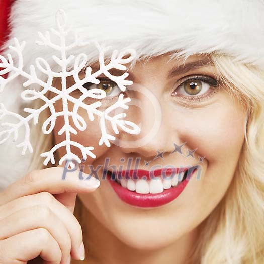 Christmas woman holding a snowflake in front of her face Christmas woman holding a snowflake in front of her face