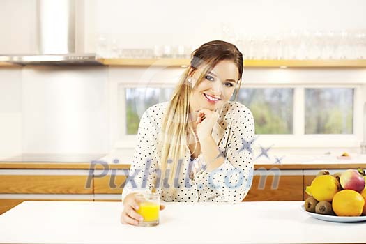 Woman having a juice in the kitchen Woman having a juice in the kitchen