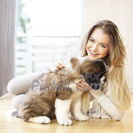Woman sitting on the floor with a puppy Woman sitting on the floor with a puppy