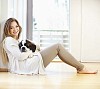 Woman sitting on the floor, holding a puppy