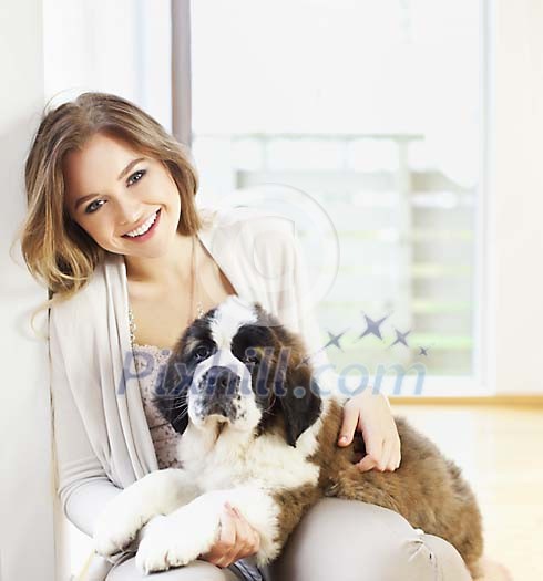 Woman sitting on the floor, holding a puppy Woman sitting on the floor, holding a puppy