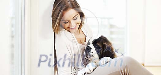 Woman smiling and looking at her puppy Woman smiling and looking at her puppy