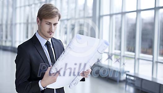 Businessman looking at the blueprint Businessman looking at the blueprint
