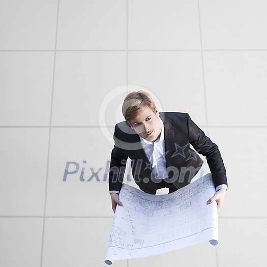 Businessman standing with a blueprint Businessman standing with a blueprint