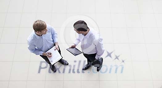 Businessmen comparing notes Businessmen comparing notes