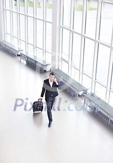 Business walking with a suitcase in a hall Business walking with a suitcase in a hall