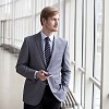 Young businessman standing next to a window