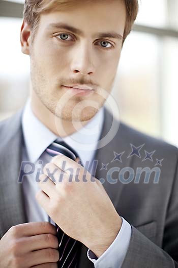 Businessman fixing his necktie Businessman fixing his necktie