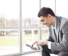 Businessman sitting with a tablet computer by the window