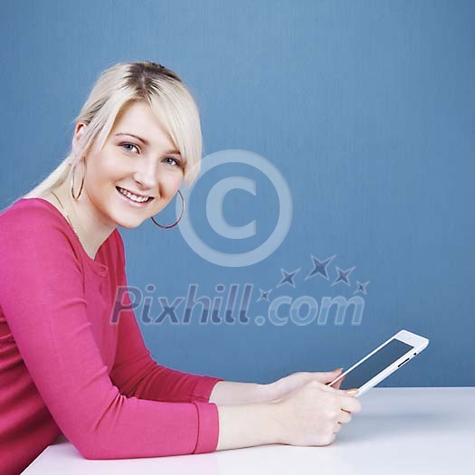 Woman by the table with a tablet computer Woman by the table with a tablet computer