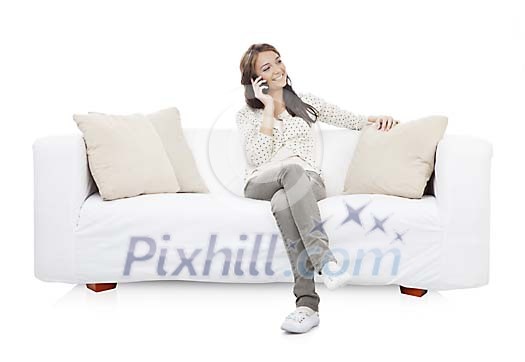 Isolated woman talking to a phone on the sofa Isolated woman talking to a phone on the sofa