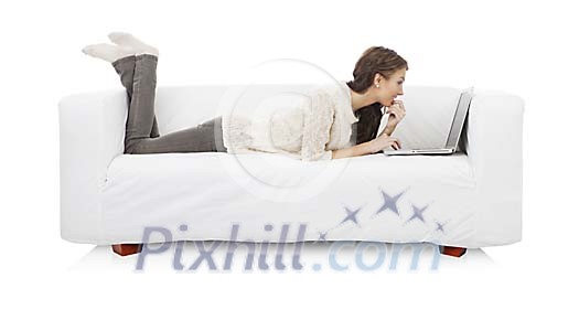 Isolated woman lieing on the sofa with a laptop Isolated woman lieing on the sofa with a laptop