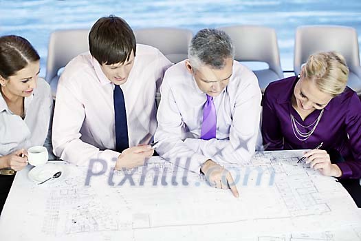 Team looking at the blueprints Team looking at the blueprints