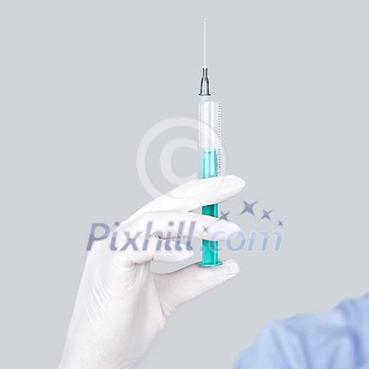Hand holding a syringe Hand holding a syringe