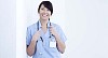 Smiling female nurse leaning against the wall