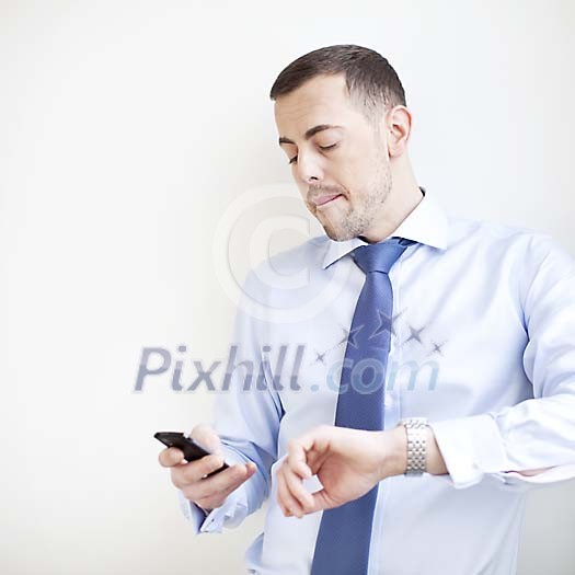 Businessman dialing a number on his phone Businessman dialing a number on his phone