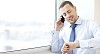 Man standing by the window, talking to a phone
