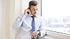 Man looking at his watch while on the phone