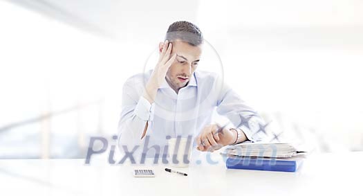 Businessman looking very stressed at his desk Businessman looking very stressed at his desk