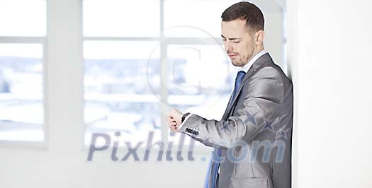 Unhappy looking businessman looking at his watch Unhappy looking businessman looking at his watch