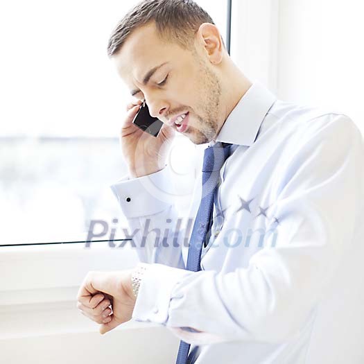 Businessman talking to a phone by the window