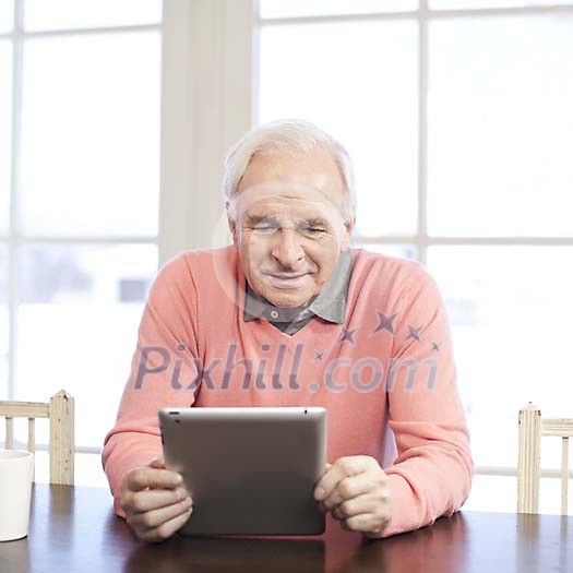 Senior man looking tablet computer screen at home Senior man looking tablet computer screen at home