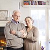 Happy senior couple in a beautiful home smiling at camera