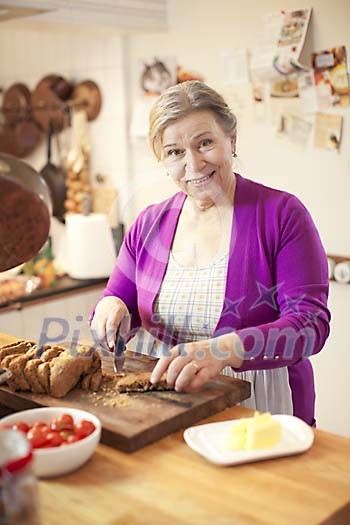 Senior woman preparing breakfast in the kitchen Senior woman preparing breakfast in the kitchen