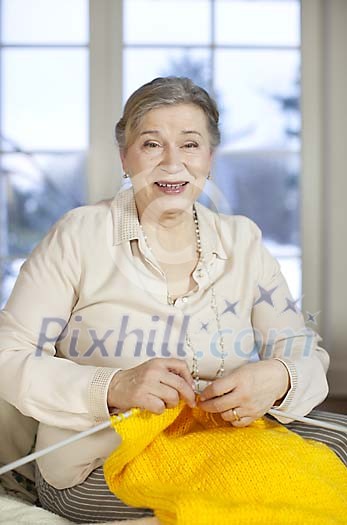 Senior woman knitting and smiling to camera Senior woman knitting and smiling to camera