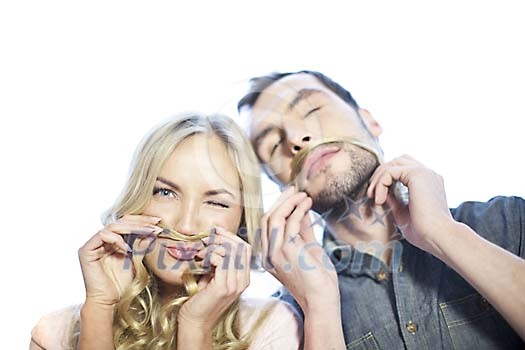 Man and woman making moustache out of womans hair Man and woman making moustache out of womans hair