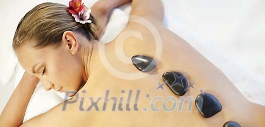 Woman enjoying a lava stone treatment Woman enjoying a lava stone treatment