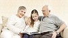 Child with her grandparents sitting on the sofa