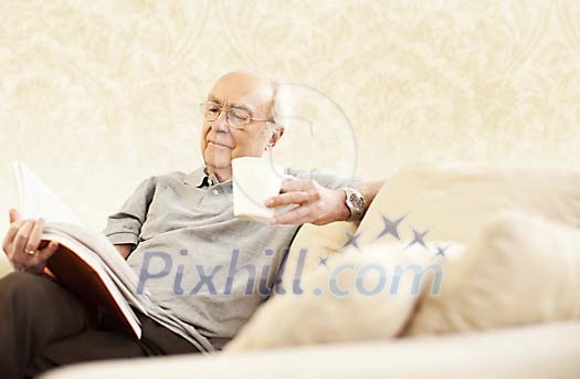 Older male sitting on the sofa and reading Older male sitting on the sofa and reading