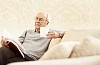 Older male sitting on the sofa and reading