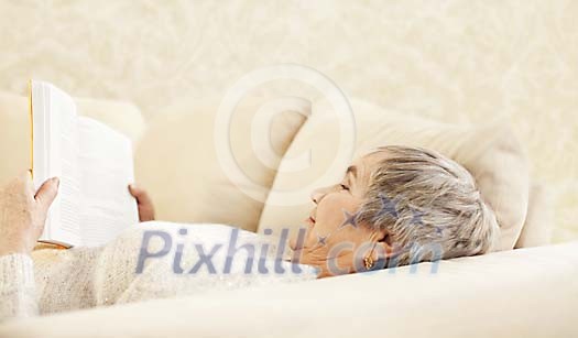 Older female reading on the sofa