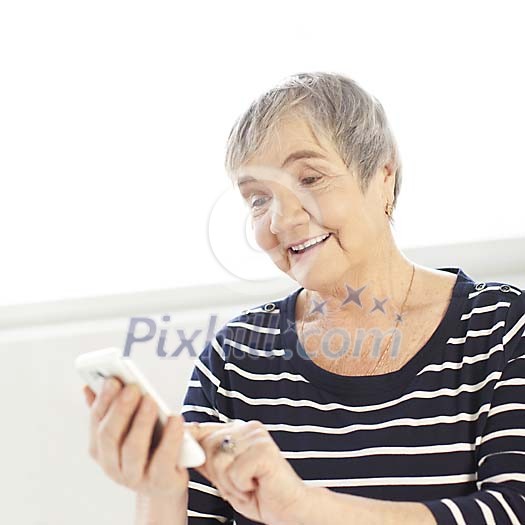 Older woman dialing a phone number Older woman dialing a phone number