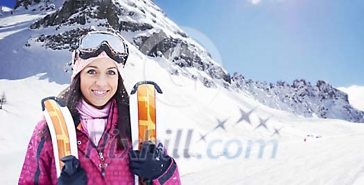 Woman standing with skis in the mountains Woman standing with skis in the mountains