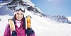 Woman standing with skis in the mountains