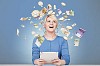 Woman sitting by her desk surrounded by flying money