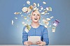 Woman sitting by her desk surrounded by flying money