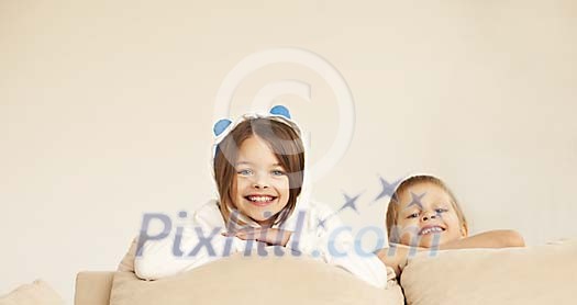 Smiling kids behind a sofa Smiling kids behind a sofa